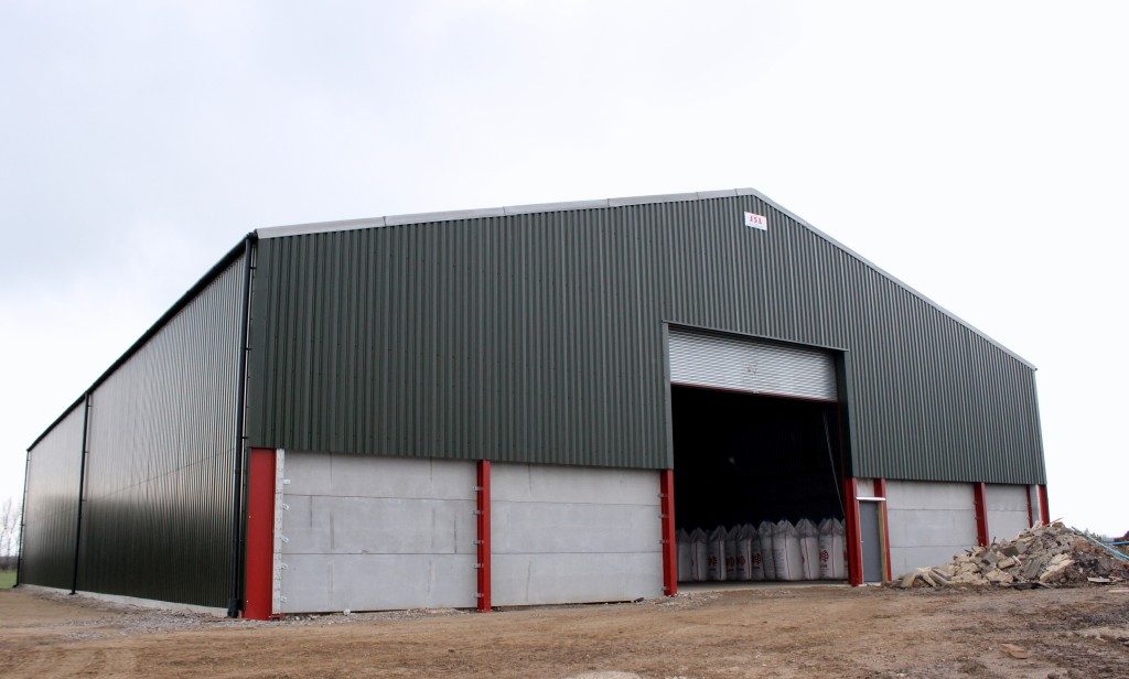 Green clad agricultural steel-framed building with concrete panel walls in North Yorkshire