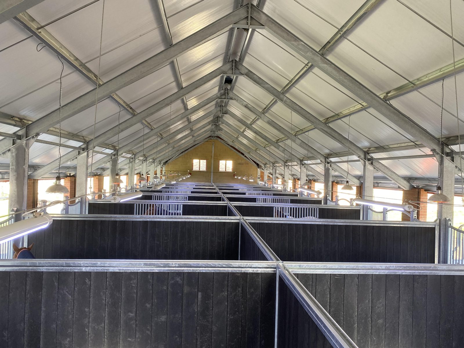 Steel-framed equestrian stable block with brick and timber finish